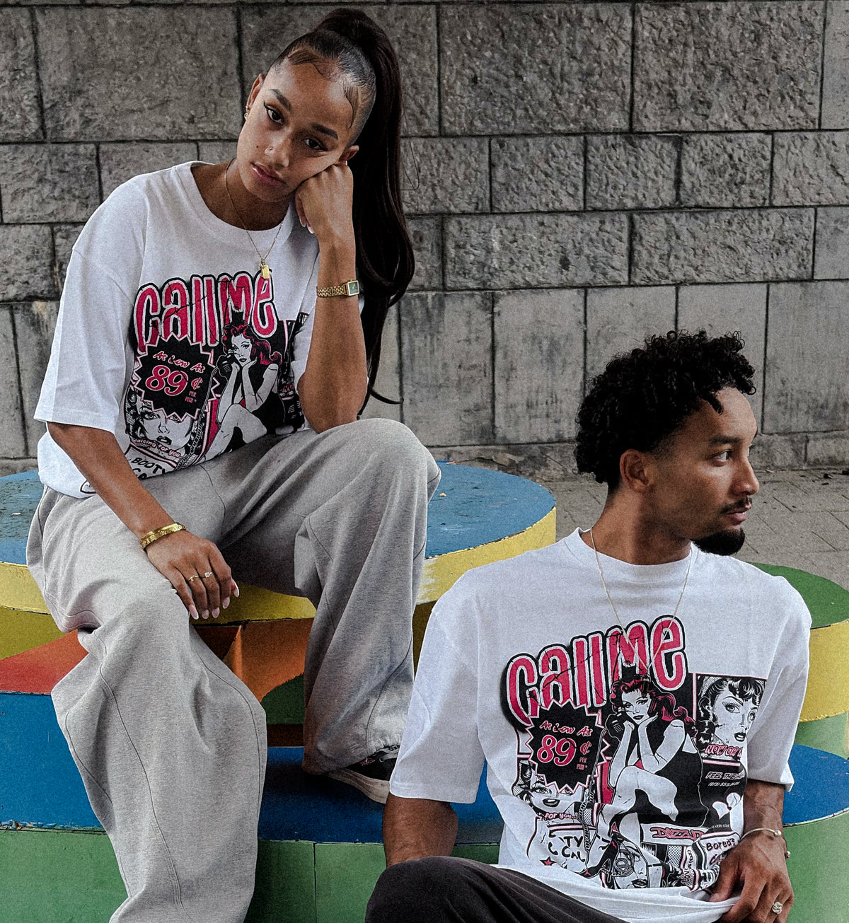 Two models wearing the white DizzyD Call Me tees.